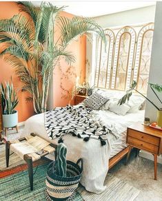 a bedroom with a bed and plants in it