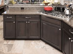 a kitchen with granite counter tops and wooden cabinets, along with pots and pans on the stove