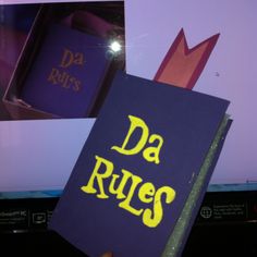 a person holding up a book that says da rues