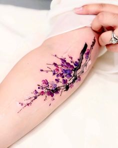 a woman's arm with purple flowers on it