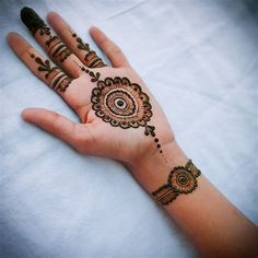 a woman's hand with henna tattoos on it