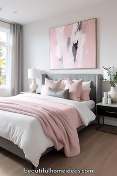 a bed with pink and grey pillows in a bedroom next to a painting on the wall