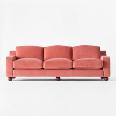 a pink couch sitting on top of a white floor