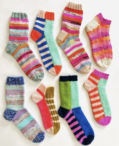 six pairs of colorful socks laid out on a white surface