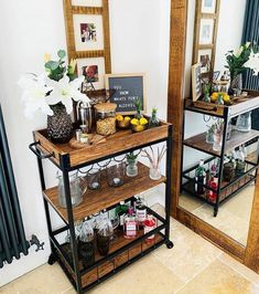 a shelf with jars and vases on it next to a mirror in a room