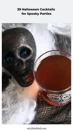 a black mask next to a cup of tea with the words 29 halloween cocktails for spooky parties