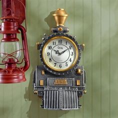 an old fashioned clock is hanging on the wall next to a lantern and light fixture