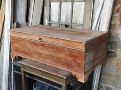 an old wooden box sitting on top of a table in front of a building with windows