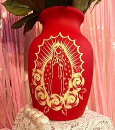 a red vase filled with flowers on top of a table