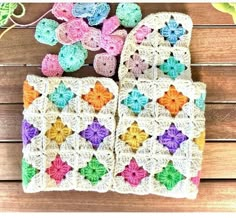 two crocheted potholders are sitting next to each other on a wooden surface