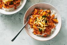 two bowls filled with rice, meat and cheese