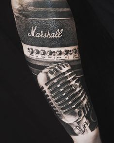 a man's arm with a microphone tattoo on it