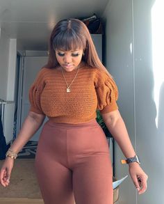 a woman wearing high waisted pants and an orange top