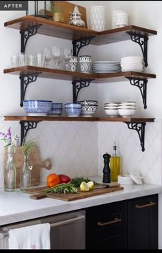 the shelves in the kitchen are filled with plates, bowls and utensils on them