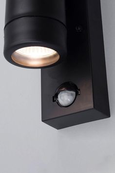 a close up of a light on a wall with a white back ground and grey walls