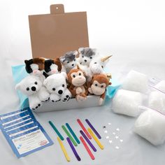 stuffed animals are sitting in a box with toothbrushes and other items around it