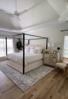 a bedroom with white bedding and wooden floors