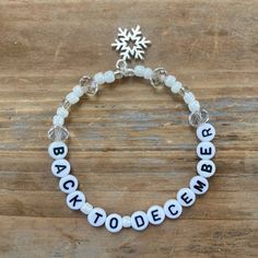 a white beaded bracelet with the words back to school written on it and a snowflake