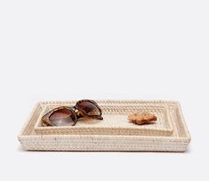 a pair of sunglasses sitting on top of a woven tray