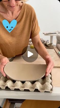 a woman is making an egg carton