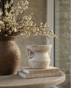 a vase and two books on a table