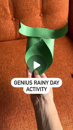 someone holding up a green paper roll with the words genius rainy day activity on it