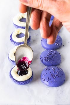 blueberry macarons are being spooned out to eat