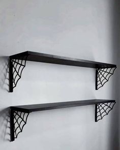 two black shelves with spider webs on them