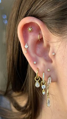 a woman's ear with three different types of piercings