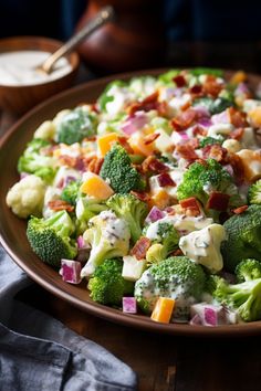 a plate full of broccoli and other vegetables on a table next to a spoon