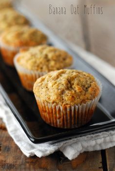 three banana oat muffins on a black tray