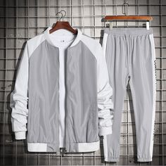 a gray and white jacket and pants on a hanger