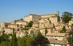 an old village is shown on top of a hill