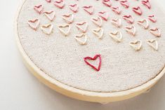 a close up of a embroidery on a white surface with a red heart in the middle