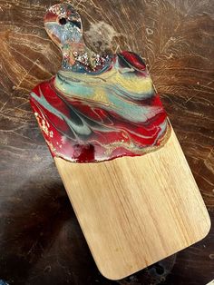 a red and blue vase sitting on top of a wooden stand