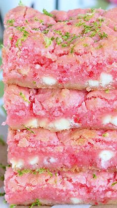 three pieces of pink cake sitting on top of a white plate next to each other