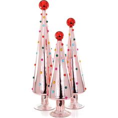 three shiny glass christmas trees with colored dots on the top and one has a red ball