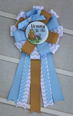 a blue and brown ribbon with a winnie the pooh badge on it