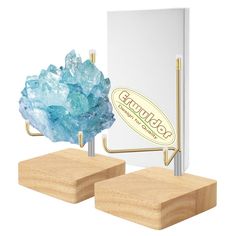 two pieces of wood stand next to each other with blue crystals on them and a sign that says gourmet