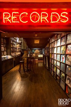 the inside of a record store with records on the wall and tables in front of it