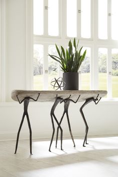 a table with two metal figures and a potted plant sitting on top of it