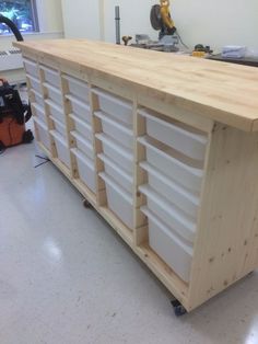 a workbench made out of plywood and white drawers