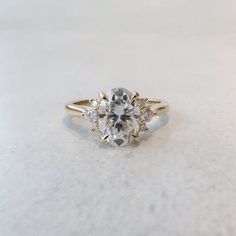 an engagement ring with three stones on the front and side, sitting on a white surface