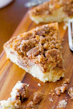 a piece of cake sitting on top of a wooden cutting board next to a fork