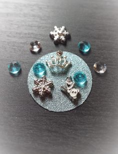 several pieces of jewelry sitting on top of a metal plate with blue glass beads around it