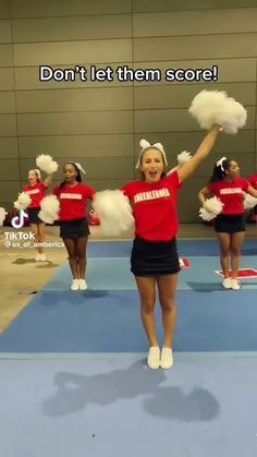 cheerleaders in red and black outfits are performing on a blue mat with the words don't let them score