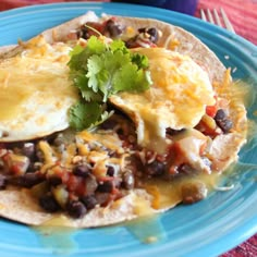 an omelet with black beans, cheese and cilantro on a blue plate