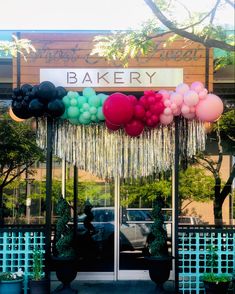 the entrance to a bakery decorated with balloons and streamers