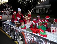 a group of people riding in the back of a truck with christmas decorations on it