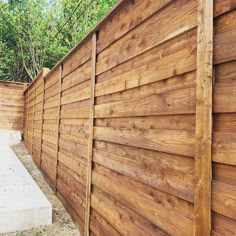 a wooden fence next to a concrete bench